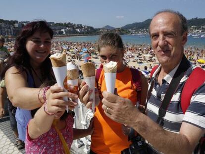 Varias personas disfrutan de un helado en San Sebastián.