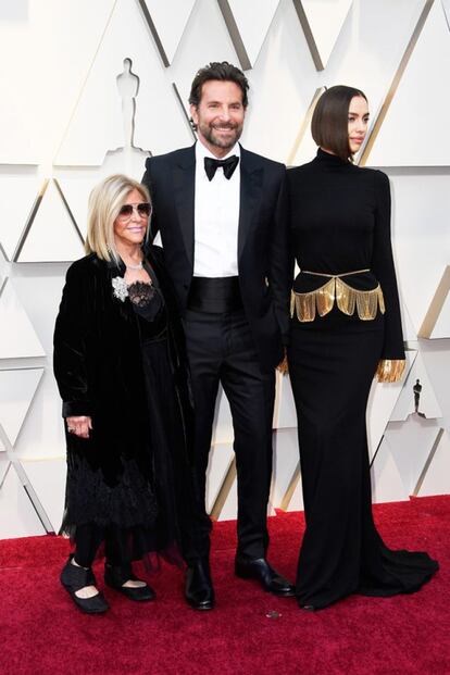 
Bradley Cooper (de Tom Ford) com a mãe, Gloria Campano, e a namorada, a modelo Irina Shayk (de Burberry). Cooper está indicado a melhor ator pelo filme 'Nasce uma estrela'.  
