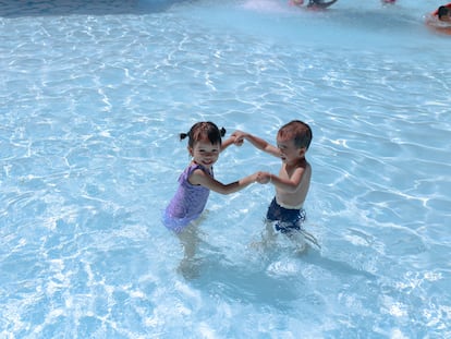 Dos niños juegan en una piscina.