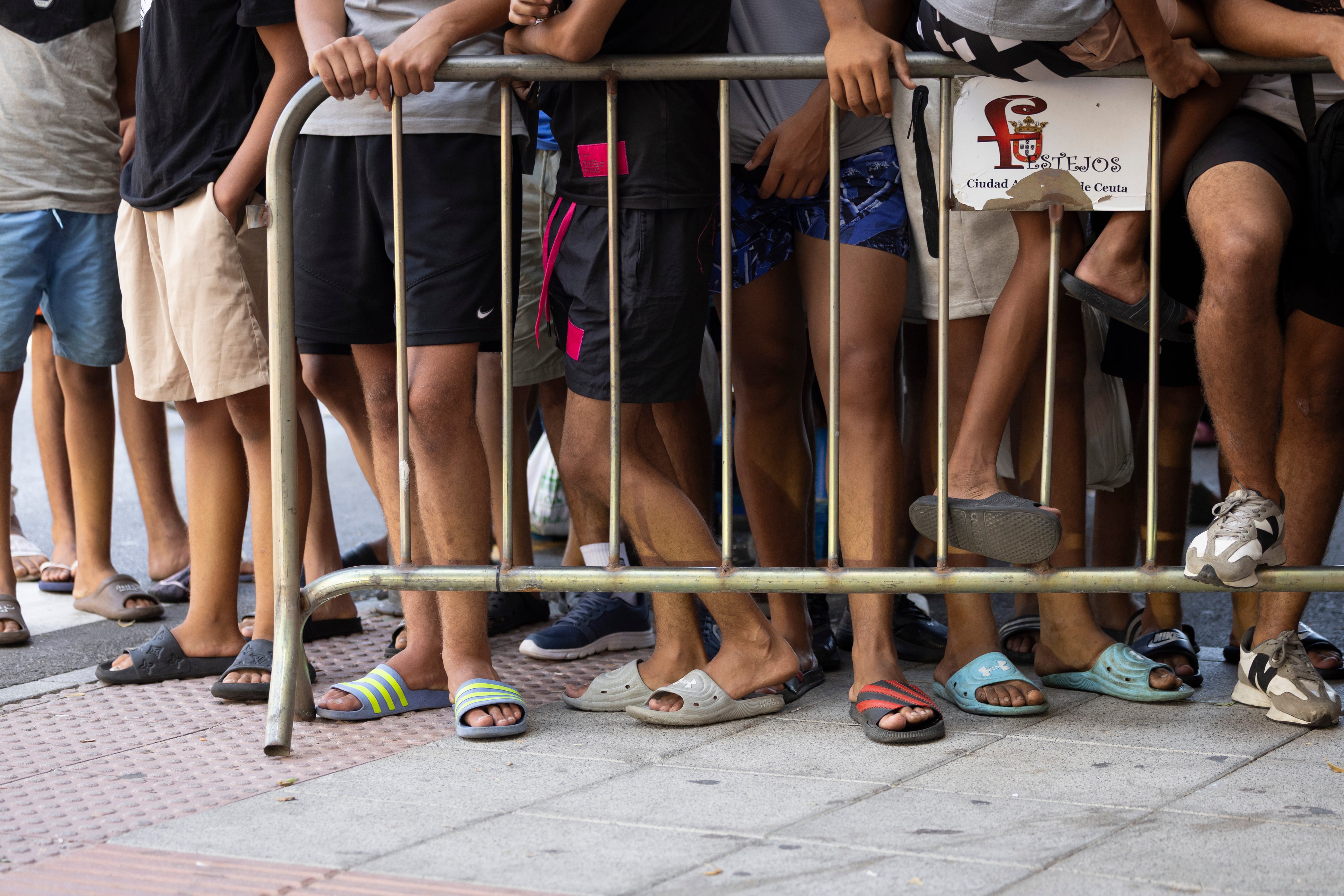 Varios de los jóvenes marroquíes llegados a finales de julio de 2026 a Ceuta, el viernes, en las inmediaciones de la comisaría de Policía Nacional.