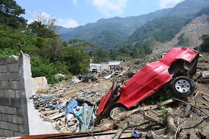 Un automóvil destruido en la aldea guatemalteca de Queja, que fue afectado por un deslizamiento de tierra provocado por las fuertes lluvias, un efecto del cambio climático en estos países de Centroamérica.
