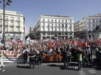 Manifestantes en la concentración de funcionarios ante la sede de la Presidencia de la Comunidad de Madrid en la Puerta del Sol, convocada hoy por los sindicatos UGT, CC.OO. y CSI-F, en protesta por los recortes anunciados por el Gobierno.