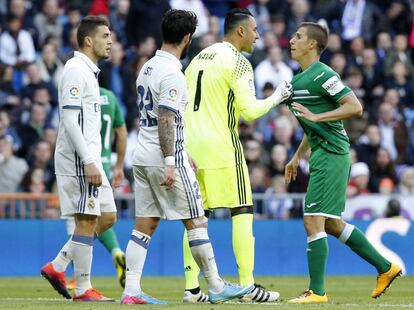 El portero del Real Madrid Keylor Navas (2 derecha) agarra de la camiseta a Alexander Szymanowski, del Leganés, ante los blancos Mateo Kovacic (izquierda) e Isco.