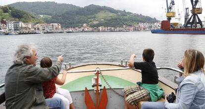 Una familia realiza un recorrido en barco por la aguas del puerto de Pasaia.