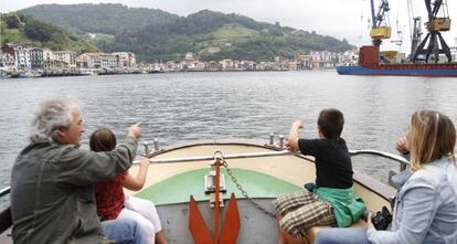 Una familia realiza un recorrido en barco por la aguas del puerto de Pasaia. 