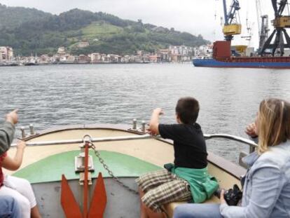 Una familia realiza un recorrido en barco por la aguas del puerto de Pasaia. 