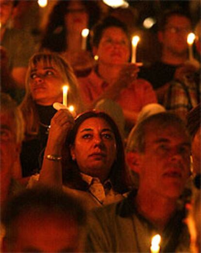 Los asistentes a la ceremonia inaugural encienden sus velas en memoria de los fallecidos por la enfermedad.