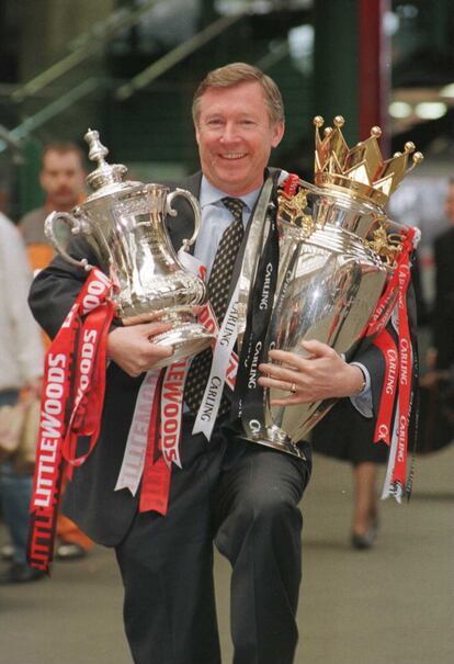 En esta foto de 1996, Sir Alex Ferguson posa con los dos títulos que conquistó aquel año con el Manchester United: la FA Cup y el trofeo de la Premier League.