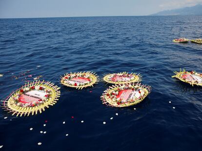 Coronas de flores con los nombres de la tripulación a bordo del submarino de la Armada indonesia 'KRI Nanggala' flotan en el mar en un homenaje por las víctimas del accidente.
