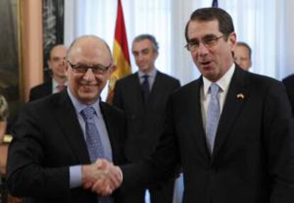 El ministro de Hacienda, Cristóbal Montoro, y el embajador de EEUU en España, Alan D. Solomont (d), antes de firmar hoy un nuevo convenio entre ambos países para evitar la doble imposición y prevenir la evasión fiscal respecto a los impuestos sobre la renta.