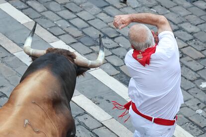 Uno de los astados pasa junto a un corredor en la calle de Mercaderes.