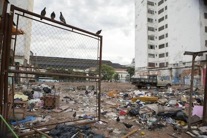 Terreno baldio usado como estacionamento e depósito de lixo.