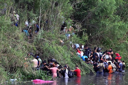 Decenas de migrantes se agolpan en la orilla del río Bravo desde Matamoros (México), este martes. 