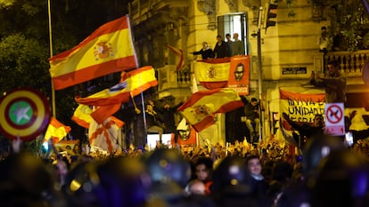 Manifestantes ondean banderas de España durante la protesta frente a la sede del PSOE en la calle Ferraz con Marqués de Urquijo de Madrid.
