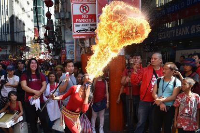 Una fakir expulsa fuego por la boca durante las celebraciones del Año Nuevo Lunar del Cerdo, en el distrito de Chinatown de Manila (Filipinas).