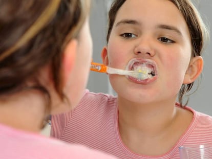 Niña se lava los dientes.