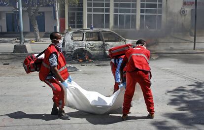 Los médicos portan el cadáver de un civil que murió durante un atentado con coche bomba. El artefecto estaba instalado en su automóvil, en Mogadishu (Somalia).