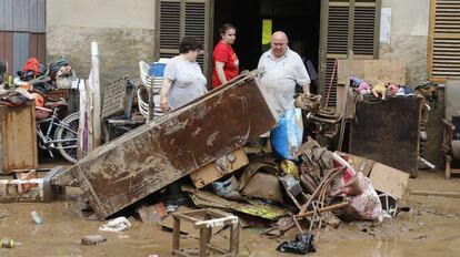 Veïns de Sant Llorenç des Cardassar netegen casa seva després del pas de la torrentada per la localitat.