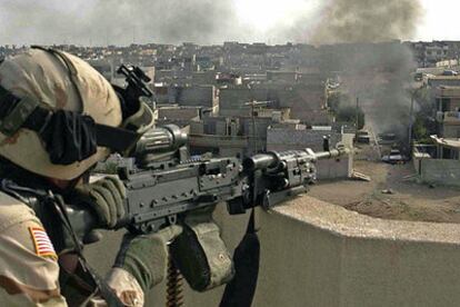 Un <i>marine</i> dispara contra posiciones de la insurgencia ayer en Mosul.