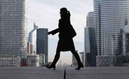 Un mujer pasa por el distrito financiero de La Défense, en París.