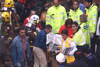 Uno de los fallecidos en el derrumbe es trasladado por bomberos y miembros del 061.