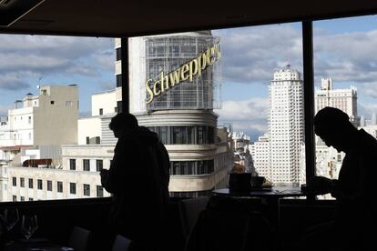 No es el más alto de los miradores de Madrid, pero tiene algo que nadie más comparte: una panorámica (en primera fila) de uno de los emblemas de la capital, el cartel de Schweppes del edificio Carrión (tras el que se encuentran <a href="https://elviajero.elpais.com/elviajero/2012/09/24/actualidad/1348514075_737947.html" target="">dos de las 'suites' más demandadas de la hostelería madrileña</a>). Además, acceder a este espacio es completamente gratis y solo hay que subir en ascensor hasta la <a href="https://www.elcorteingles.es/aptc/gourmet-experience/gran-via/" target="">novena planta de El Corte Inglés de Callao</a>, lleno de delicatesen para comprar o para degustar allí mismo. Podemos tomar algo en un restaurante mexicano o en un japonés, o pedir pizzas y hamburguesas ‘gourmet’. Pero lo mejor es asomarnos a la terraza (siempre con turistas cámara en mano) para contemplar la vista más típica de la Gran Vía, con el ya mítico luminoso en primer término y el edificio Torre Madrid, en la plaza de España, al fondo.