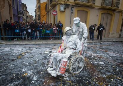 La jornada finalizará esta noche con el 'baile del Virrey' y la 'dançà', en las que participarán mujeres vestidas con lujosos trajes, hombres cubiertos con elegantes capas, y otros peculiares personajes conocidos como 'els tapats', que van disfrazados de las formas más variopintas, cubiertos con capa y máscaras. Una multitud observa a dos participantes, cubiertos de harina tras la batalla.