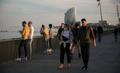 Gente paseando y haciendo deporte por el paseo marítimo de Barcelona, el domingo.