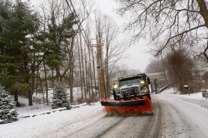 A snowplow removes the snow on Maple Street in Brattleboro, Vt., while the snow falls on Saturday, March 23, 2024.