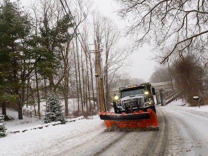 A snowplow removes the snow on Maple Street in Brattleboro, Vt., while the snow falls on Saturday, March 23, 2024.