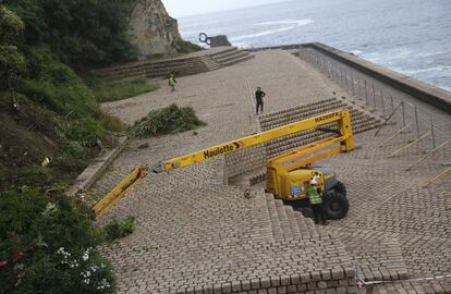 Una máquina desbrozadora trabaja en el Paseo del Peine del Viento, en San Sebastián.