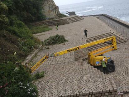 Una máquina desbrozadora trabaja en el Paseo del Peine del Viento, en San Sebastián.