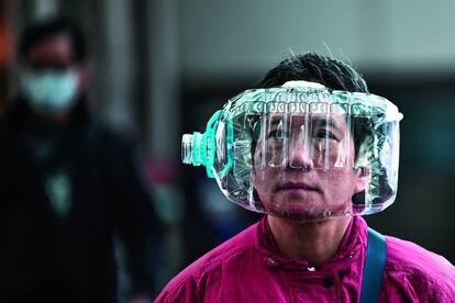 Un ciudadano de Hong Kong se protege con una botella de plástico el pasado 31 de enero, días después de que fuera decretado el cierre de Wuhan, en China.