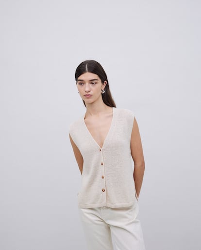 Este chaleco de punto liso, confeccionado en una mezcla de algodón y lino, es una prenda ligera y versátil para el verano. De diseño recto, con escote de pico, botones estilo carey y aberturas laterales se nota la experiencia de Yerse, marca barcelonesa experta en prendas de punto desde 1964.