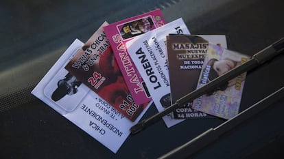 Anuncios de negocios de prostitución en el parabrisas de un vehículo en Madrid.