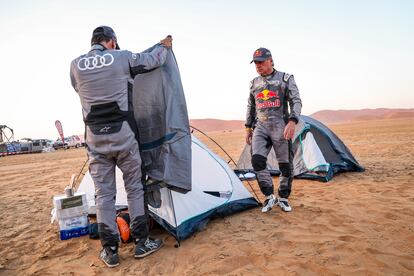 Carlos Sainz y Lucas Cruz preparan la tienda de campaña para dormir en el desierto.