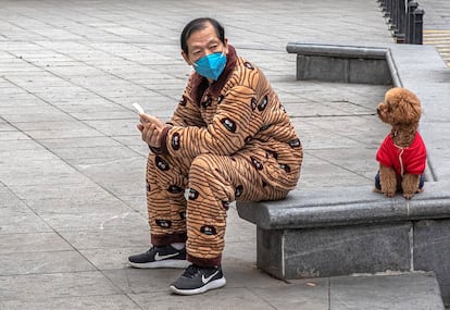 Un hombre consulta su móvil en la ciudad china de Wuhan. EFE/EPA/ROMAN PILIPEY RECROPPED VERSION