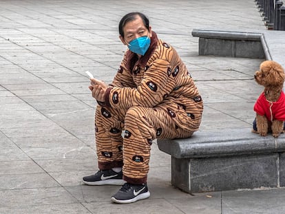 Un hombre consulta su móvil en la ciudad china de Wuhan. EFE/EPA/ROMAN PILIPEY RECROPPED VERSION