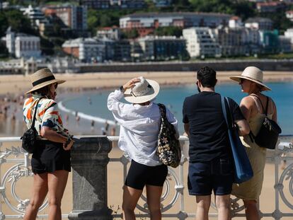 Unos turistas visitan este martes la playa de la Concha de San Sebastián.