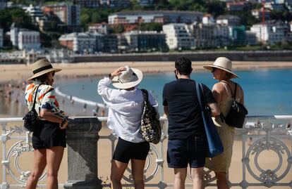 Unos turistas visitan este martes la playa de la Concha de San Sebastián.