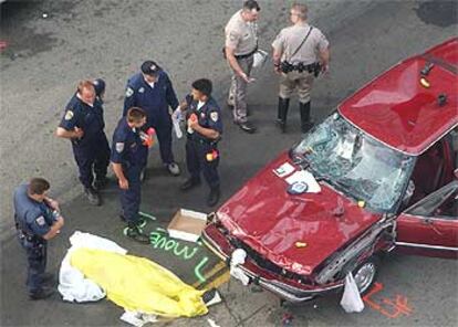 Una de las víctimas yace cubierta junto al coche que causó el accidente.