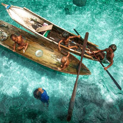 Niños del pueblo indígena bajau, también conocido como “los gitanos del mar”, bucean y juegan en las barcas que flotan sobre un mar de intenso azul celeste. Los bajaus son conocidos por sus increíbles habilidades para el buceo libre; llegan a alcanzar profundidades de entre 10 y 20 metros durante cinco minutos seguidos para pescar. Algunos países están intentando sedentarizarlos en tierra firme. Bajau, Malasia, 2013.