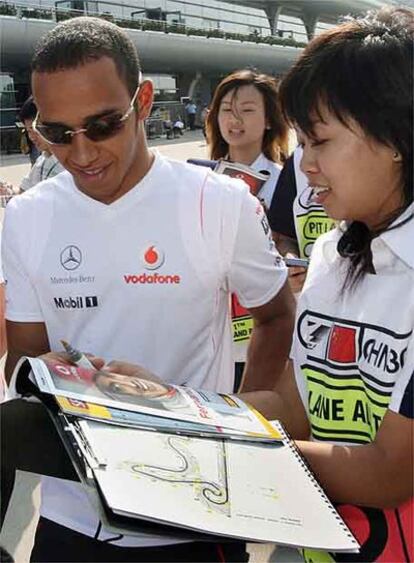 Lewis Hamilton firma un autógrafo con el rostro de Fernando Alonso en el circuito de Shangai