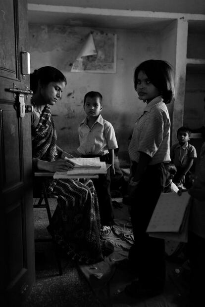 2011 India. Anita Kumar, del centro educativo Mera Parivar, de la ONG Naya Nagar, atiende a sus alumnos. Esta es una “escuela puente” para insertar a niños de 3 a 12 años de familias marginadas y con pocos recursos económicos de la comunidad de Rajeev Nagar en el sistema educativo del país. Es un centro de día donde los niños aprenden a leer y a escribir con el objetivo de ayudarles a aprobar los exámenes de admisión en los centros públicos y privados de la zona. Actualmente la escuela cuenta con 150 niños y más de 250 ya han dado el salto y accedido a la escolarización en colegios donde podrán obtener un título. Además de las clases, reciben una comida diaria y atención sanitaria. La imagen recibió el primer premio de fotografía en el certamen internacional que celebra la Fundación de Derechos Civiles en 2011.