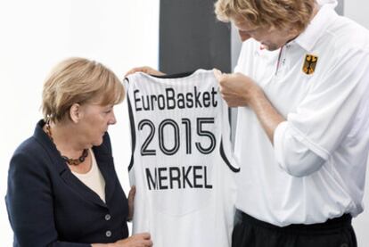 Merkel recibe una camiseta del jugador de baloncesto Nowitzki.