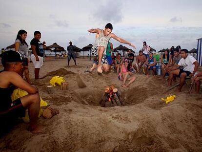 Un joven salta una hoguera en la noche de San Juan en la playa de la Malvarrosa en Valencia.