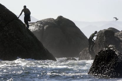 Dos <i>percebeiros</i> mientras faenan en las rocas de Lira, en la Costa da Morte.