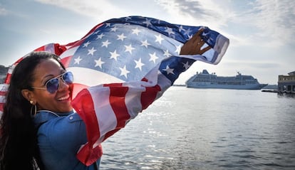 Una ciudadana cubana ondea una bandera de su país desde el Malecón. Al fondo, el crucero Adonia, el primero en unir EE UU y Cuba en 50 años.