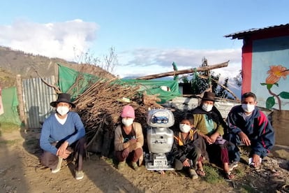 Walter Velásquez Godoy, a la izquierda, posa con algunos de los niños de áreas rurales que han recibido clases gracias al robot que él mismo inventó y con los padres de estos.