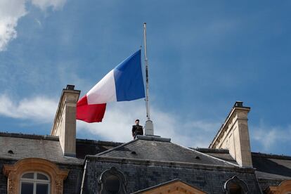 Un soldado se mantiene firme al lado de una bandera francesa a media asta en el Palacio del Elíseo en París, Francia. 